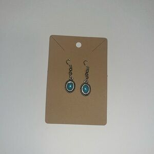 Vintage looking handmade dangly earrings with a blue stone in the center